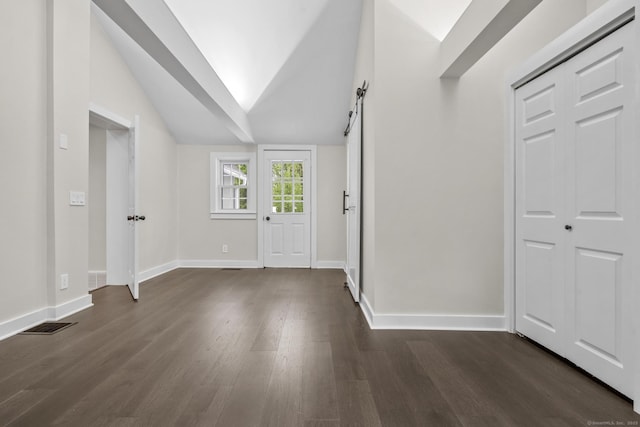 foyer featuring dark wood finished floors, baseboards, and vaulted ceiling
