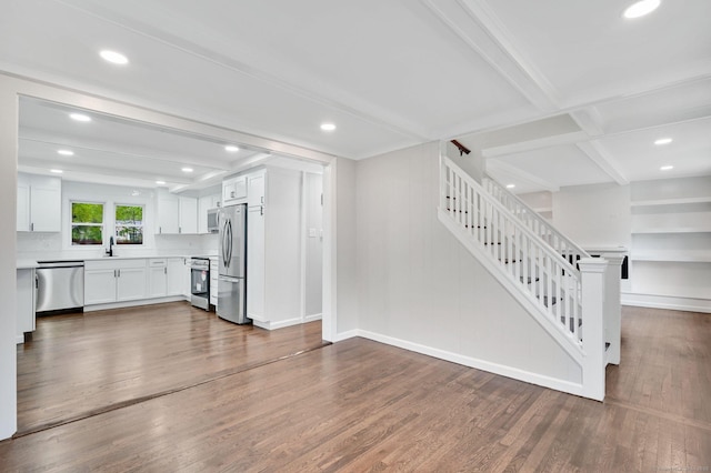unfurnished living room with stairs, wood finished floors, recessed lighting, baseboards, and beamed ceiling