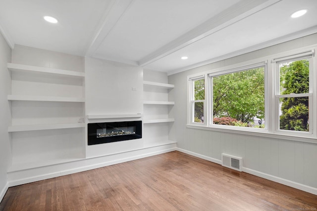 unfurnished living room featuring wood finished floors, a glass covered fireplace, baseboards, and recessed lighting
