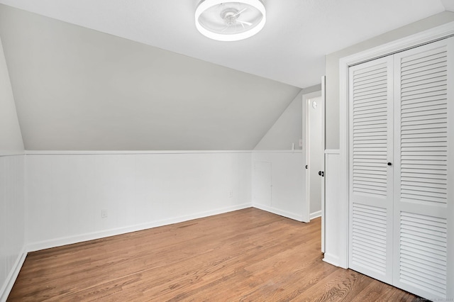 bonus room with lofted ceiling, light wood finished floors, and baseboards