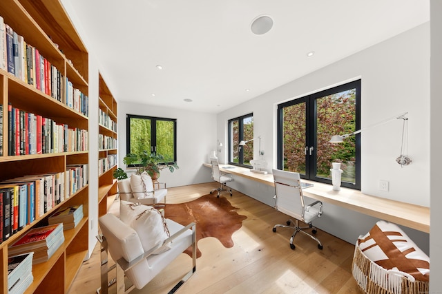 home office featuring wood finished floors, recessed lighting, french doors, and built in study area