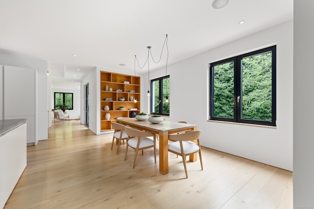 dining area with light wood-type flooring and recessed lighting