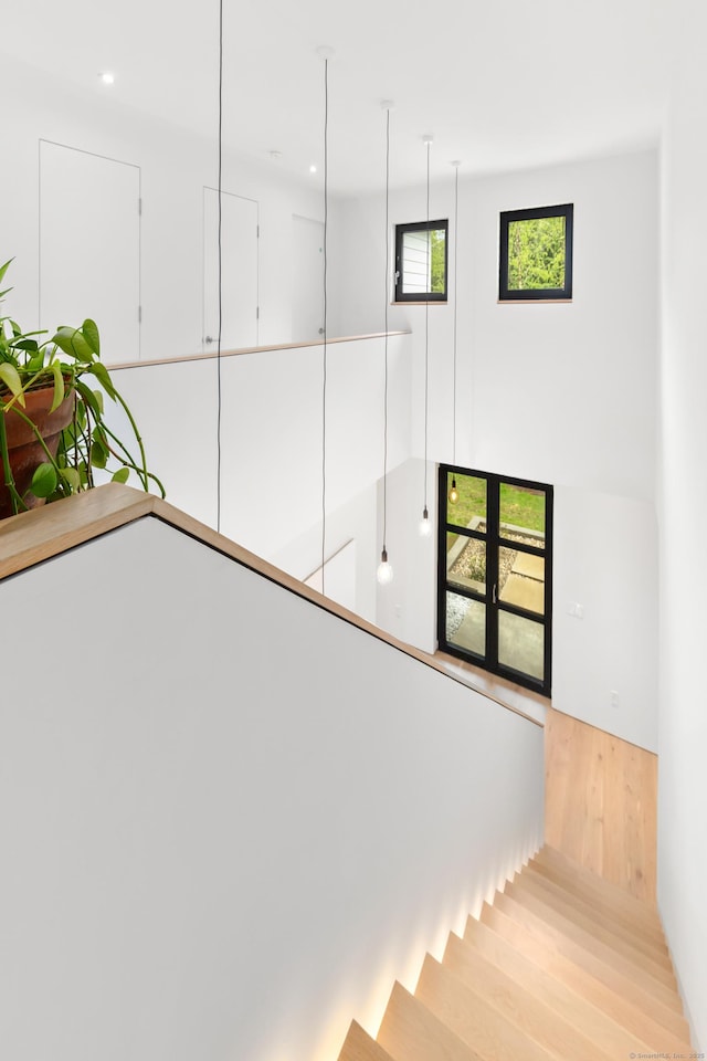 stairway with wood finished floors and recessed lighting