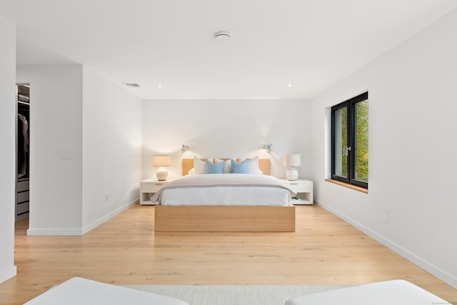bedroom with baseboards, wood finished floors, and recessed lighting