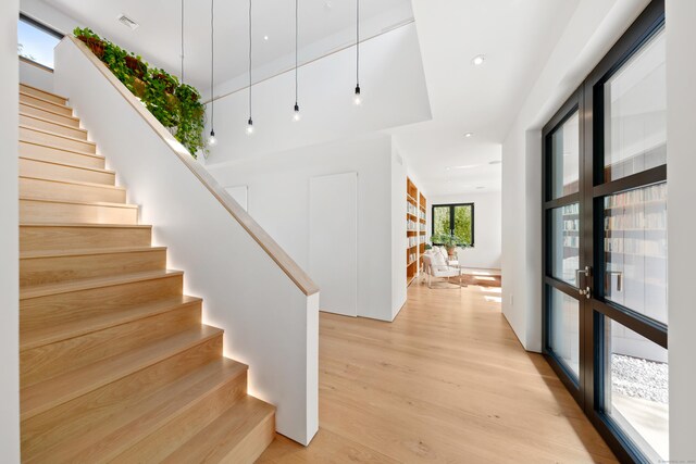 staircase with wood finished floors and recessed lighting