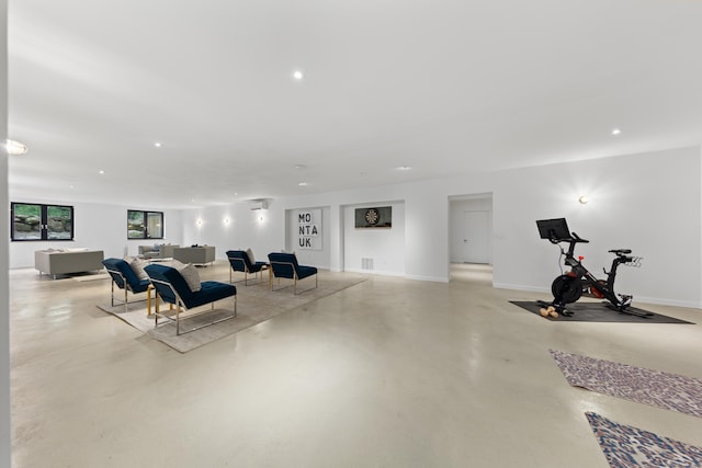 living room featuring finished concrete floors, recessed lighting, and baseboards