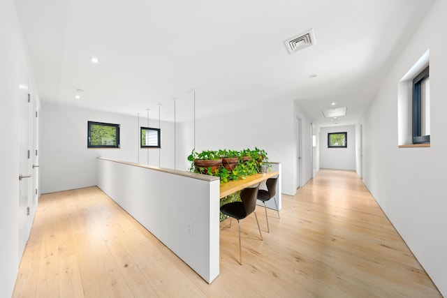 hall with light wood finished floors and recessed lighting