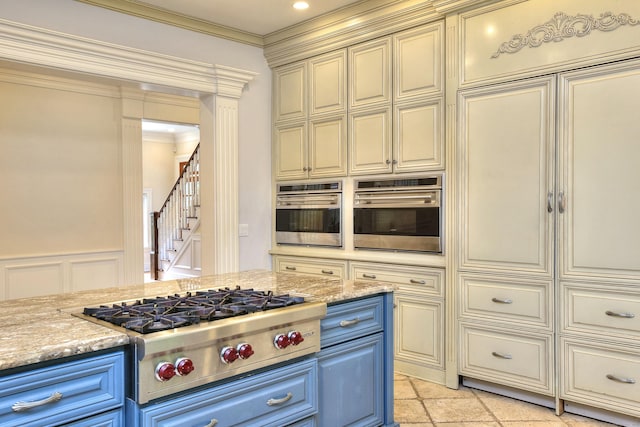 88 Merry Meet Cir, Fairfield, CT 06824 - kitchen featuring blue cabinetry, cream cabinets, appliances with stainless steel finishes, a decorative wall, and ornamental molding