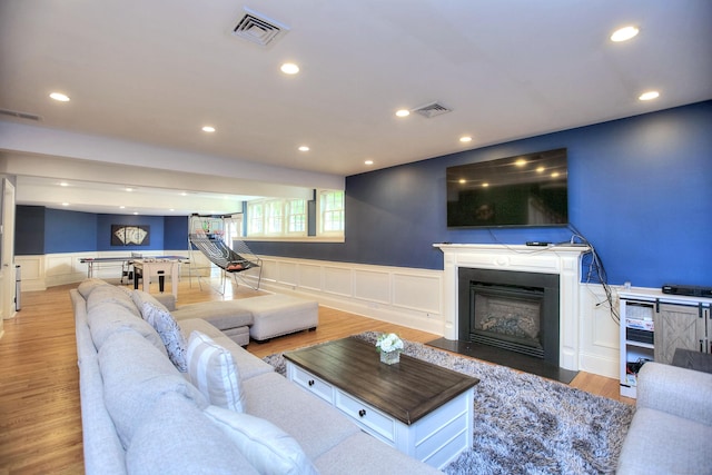 88 Merry Meet Cir, Fairfield, CT 06824 - living area featuring a decorative wall, wainscoting, a fireplace with flush hearth, recessed lighting, and wood finished floors