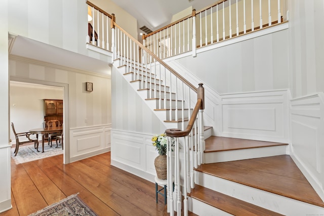 1 Dover Cir, Newtown, CT 06470 - stairs with a decorative wall, hardwood / wood-style floors, and a wainscoted wall