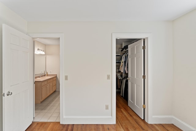 1 Dover Cir, Newtown, CT 06470 - unfurnished bedroom featuring a walk in closet, light wood-style flooring, and baseboards