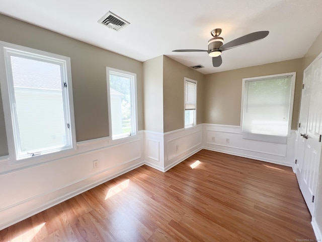 279 New Haven Ave Apt H, Milford, CT 06460 - empty room featuring light wood finished floors, wainscoting, and ceiling fan