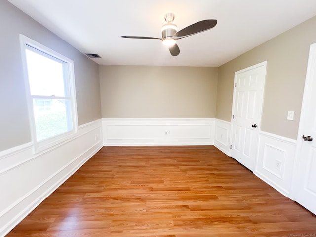 279 New Haven Ave Apt H, Milford, CT 06460 - spare room featuring ceiling fan, light wood finished floors, and a wainscoted wall
