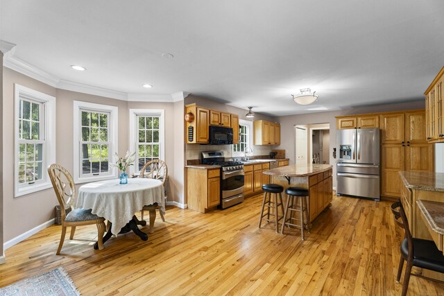 9 Benham Hill Pl, Hamden, CT 06514 - kitchen featuring appliances with stainless steel finishes, a kitchen island, crown molding, light wood-style floors, and a kitchen breakfast bar