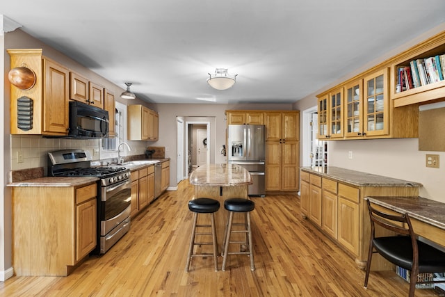 9 Benham Hill Pl, Hamden, CT 06514 - kitchen featuring appliances with stainless steel finishes, a breakfast bar area, a kitchen island, and light wood-style floors