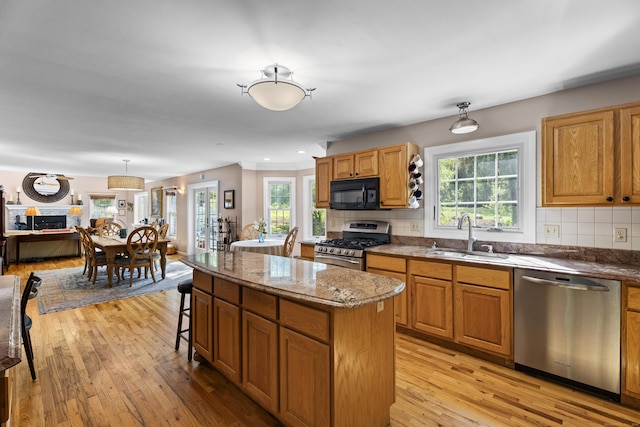 9 Benham Hill Pl, Hamden, CT 06514 - kitchen with stainless steel appliances, a sink, a center island, light wood-style flooring, and decorative backsplash