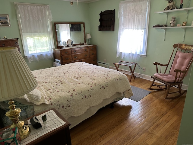 119 Chambers St, Manchester, CT 06042 - bedroom featuring multiple windows, wood finished floors, baseboards, and a baseboard heating unit