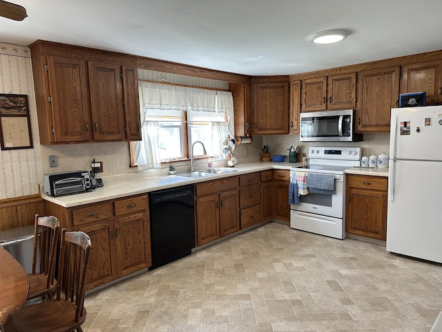 119 Chambers St, Manchester, CT 06042 - kitchen featuring white appliances, a sink, light countertops, and brown cabinetry