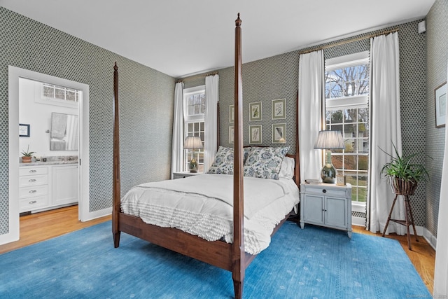 bedroom with wallpapered walls and wood finished floors