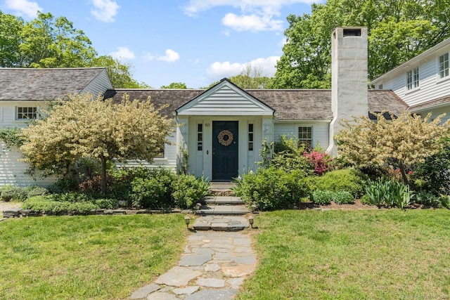 view of front of home with a front yard and a chimney