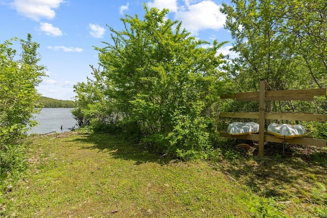 view of green lawn featuring a water view