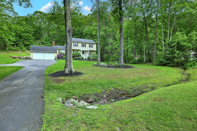 220 Northwood Dr, Guilford, CT 06437 - colonial home with driveway, an attached garage, a front yard, a chimney, and a forest view