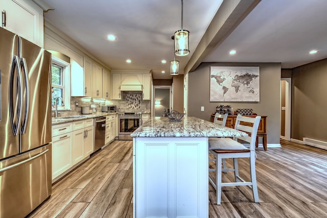 220 Northwood Dr, Guilford, CT 06437 - kitchen featuring appliances with stainless steel finishes, a sink, light wood-style flooring, a kitchen island, and recessed lighting