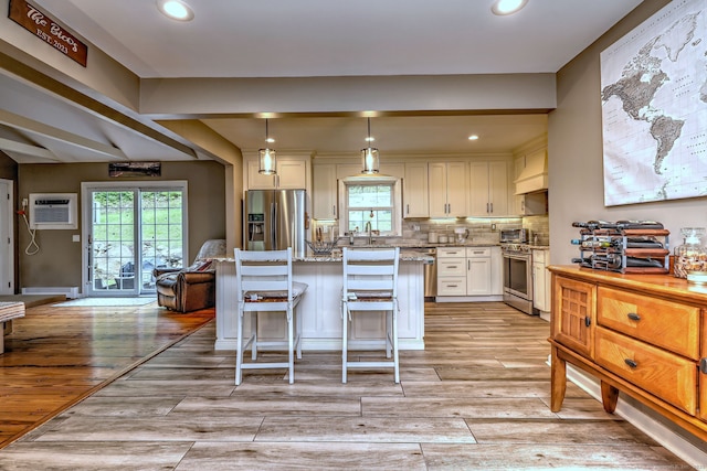 220 Northwood Dr, Guilford, CT 06437 - kitchen with appliances with stainless steel finishes, a wall mounted air conditioner, a kitchen island, recessed lighting, and white cabinets