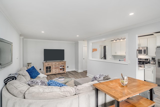 living room featuring ornamental molding, light wood finished floors, recessed lighting, and baseboards