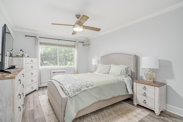 bedroom featuring ornamental molding, light wood-style floors, a wall mounted AC, a ceiling fan, and baseboards