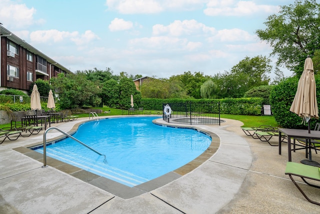 community pool with a patio and fence