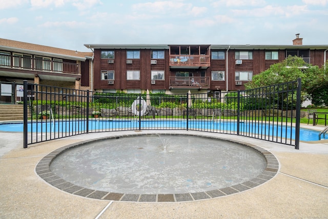 view of community with a swimming pool and fence