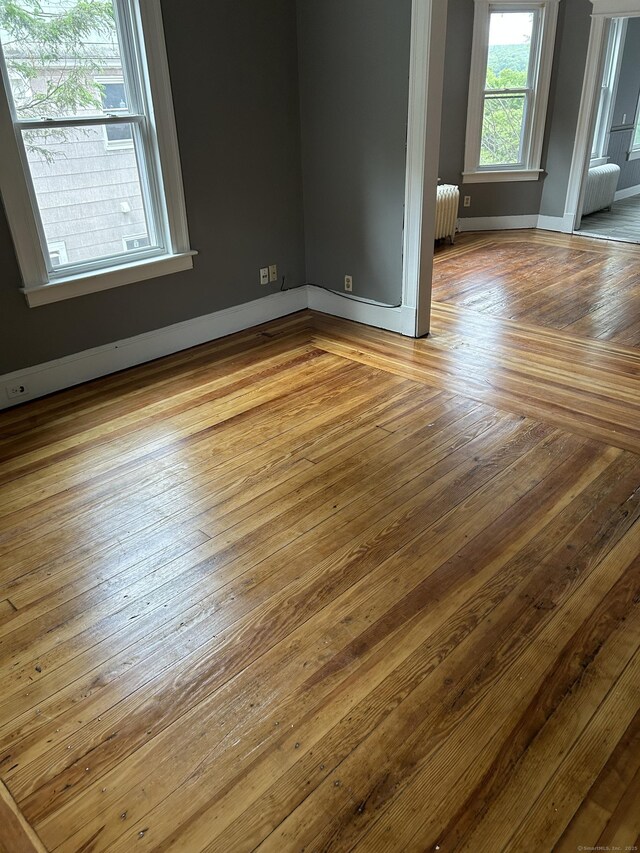 215 Lincoln St, Waterbury, CT 06710 - spare room featuring radiator heating unit, wood-type flooring, and baseboards