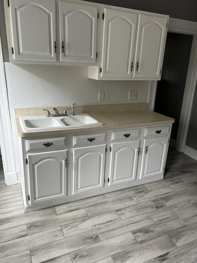 215 Lincoln St, Waterbury, CT 06710 - kitchen featuring a sink, white cabinets, light wood-type flooring, and light countertops
