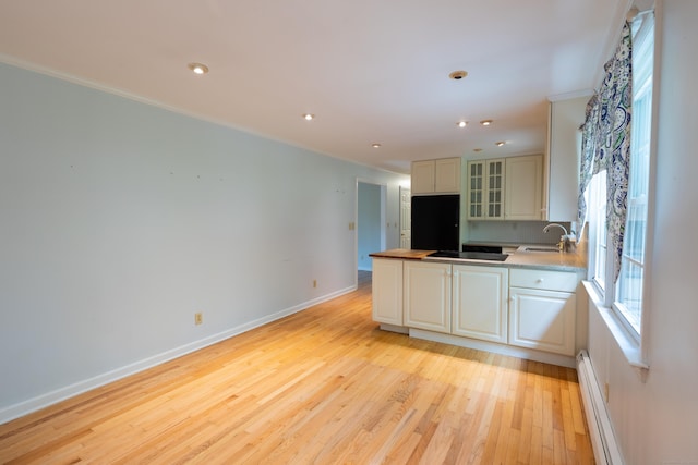 138 White Birch Dr, Guilford, CT 06437 - kitchen with a sink, a baseboard heating unit, ornamental molding, light wood finished floors, and a peninsula