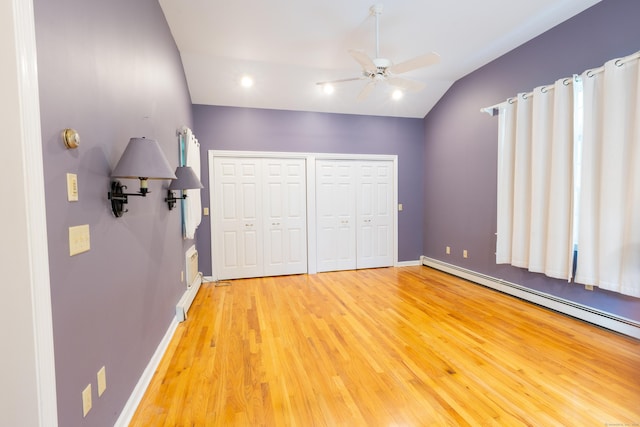 138 White Birch Dr, Guilford, CT 06437 - unfurnished bedroom featuring baseboard heating, vaulted ceiling, multiple closets, light wood-type flooring, and baseboards