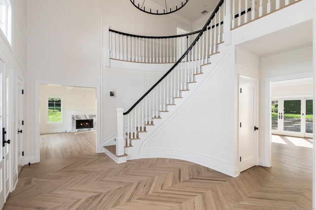 19 Stone Fence Ln, Stamford, CT 06903 - foyer entrance featuring a towering ceiling, stairs, a decorative wall, healthy amount of natural light, and a high end fireplace