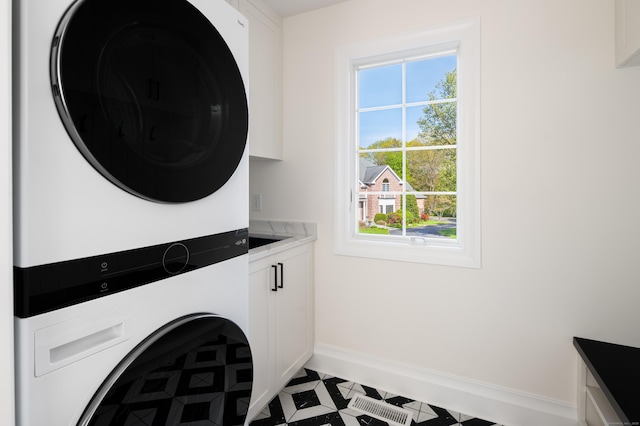 19 Stone Fence Ln, Stamford, CT 06903 - laundry area featuring cabinet space, stacked washer / dryer, and baseboards