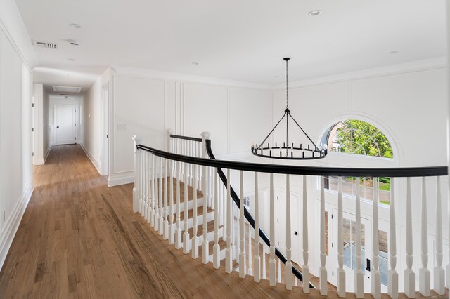 19 Stone Fence Ln, Stamford, CT 06903 - hallway featuring a chandelier, an upstairs landing, wood finished floors, and ornamental molding