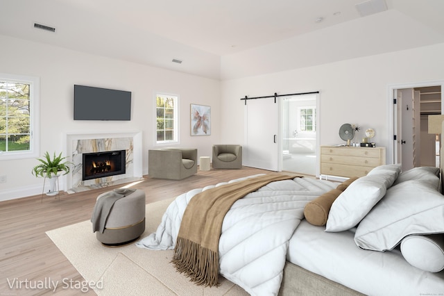 19 Stone Fence Ln, Stamford, CT 06903 - bedroom with multiple windows, wood finished floors, a barn door, lofted ceiling, and baseboards