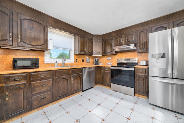 995 Maple St, Wethersfield, CT 06109 - kitchen with appliances with stainless steel finishes, a sink, under cabinet range hood, light countertops, and dark brown cabinets