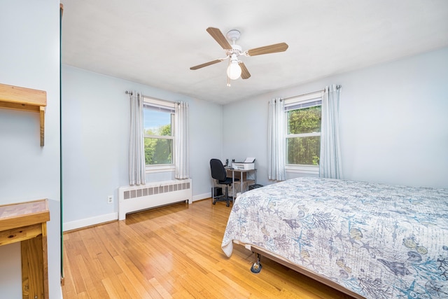 995 Maple St, Wethersfield, CT 06109 - bedroom with radiator heating unit, light wood-type flooring, baseboards, a ceiling fan, and a desk