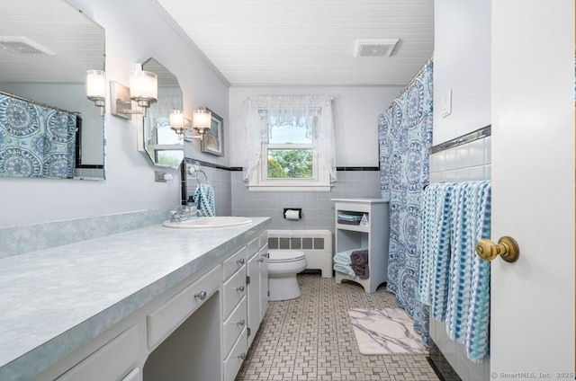 995 Maple St, Wethersfield, CT 06109 - bathroom with radiator heating unit, tile walls, toilet, vanity, and a wainscoted wall
