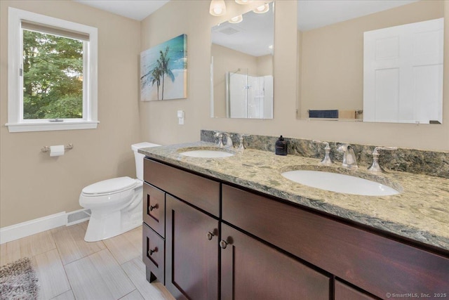 full bathroom with toilet, a stall shower, baseboards, and double vanity