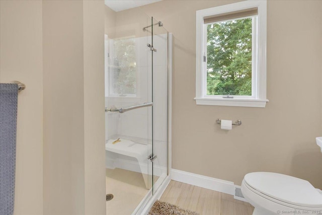 bathroom with a shower stall, healthy amount of natural light, and baseboards