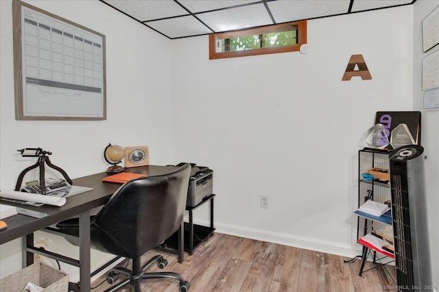 office space featuring wood finished floors, baseboards, and a drop ceiling