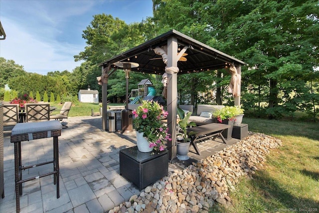 view of patio featuring a storage unit, an outbuilding, and a gazebo