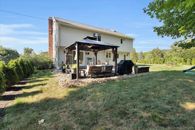 rear view of house featuring a gazebo, a chimney, central air condition unit, a patio, and a yard