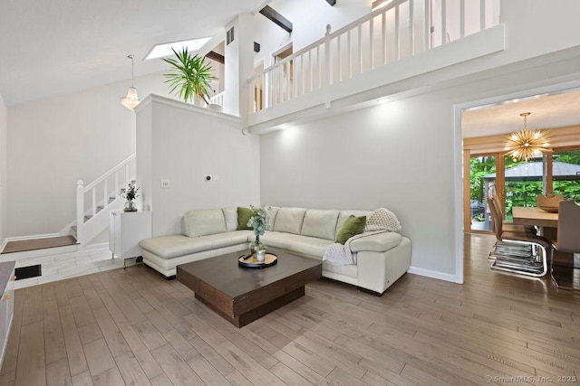 14 Stakey Farm Rd, Southington, CT 06489 - living room with high vaulted ceiling, wood finished floors, a chandelier, stairway, and baseboards