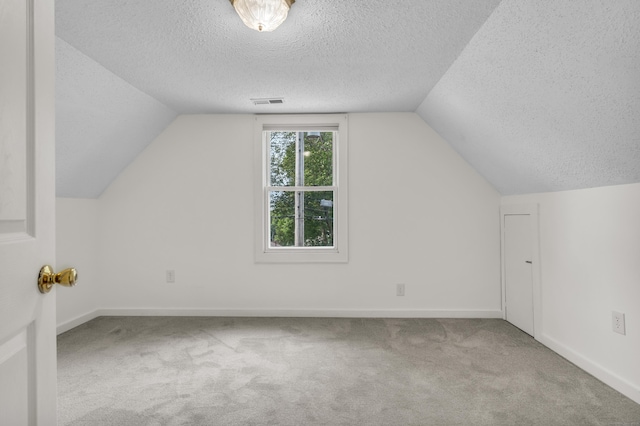 9 Florence St, East Haven, CT 06513 - additional living space with a textured ceiling, carpet floors, vaulted ceiling, and baseboards
